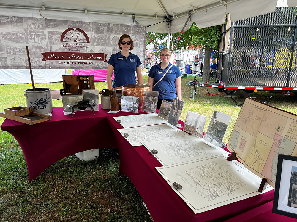 Amy Leiser and Julia Burns display local artifacts, photographs, and maps at the 100th Anniversary West End Fair in Gilbert.